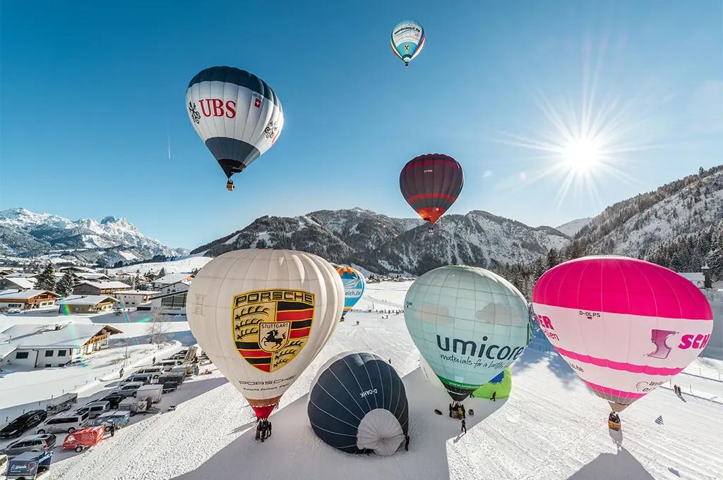 Heißluftballons starten bei strahlendem Sonnenschein im verschneiten Tannheimer Tal – spektakuläres Winter-Incentive mit Alpenpanorama und exklusivem Teamerlebnis in luftiger Höhe