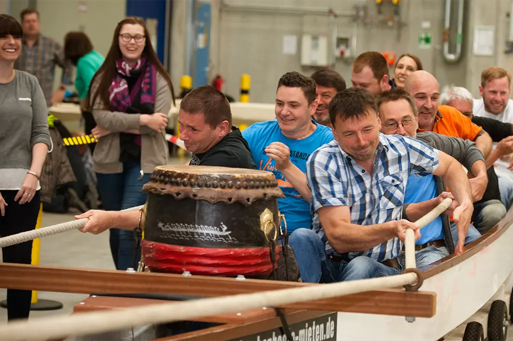 Team bei Indoor-Drachenboot-Challenge beim Winter-Teamevent in Stuttgart – mitreißendes Teambuilding mit Rhythmus, Power und Spaß im geschützten Indoorbereich