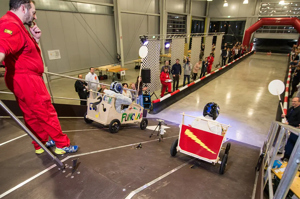 Start eines Indoor-Seifenkistenrennens beim Winter-Teamevent in München – kreatives Teambuilding mit Geschwindigkeit, Wettbewerb und Teamwork unter Dach