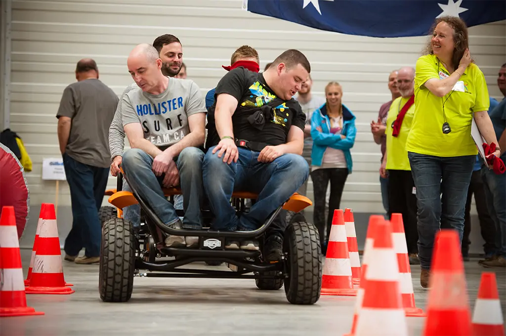 Teilnehmer navigieren blind durch Indoor-Parcours beim Winter-Teamolympiade-Event in Frankfurt – kreative Teambuilding-Aufgabe mit Vertrauen, Kommunikation und Spaß