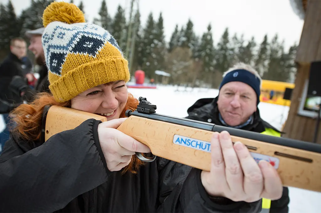 Teilnehmerin zielt beim mobilen Biathlon-Teamevent mit Lasergewehr in Bad Herrenalb – sportliches Wintererlebnis mit Präzision, Spaß und Teamchallenge im Schnee